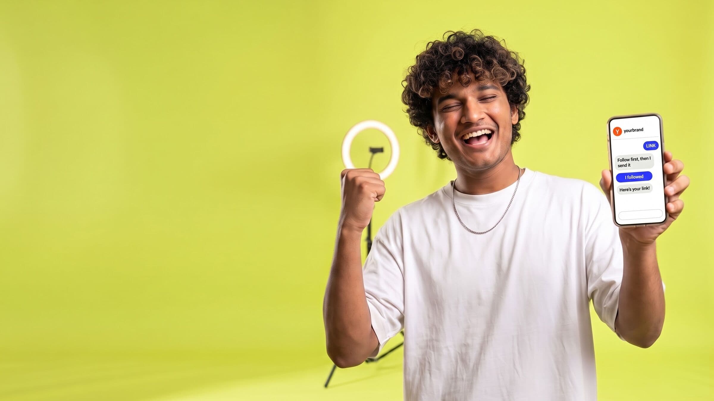 A creator cheering with his phone up in front of a ring light